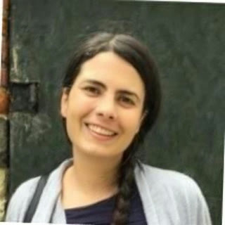 Caterina Tornelli, smiling, with long dark hair in a braid.